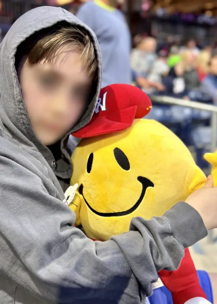 child with Woosox Smiley mascot plush